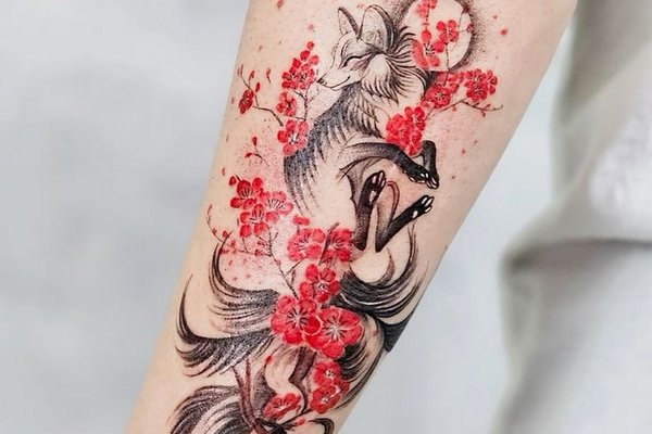 Тату кицуне з квітами сакури на передпліччі