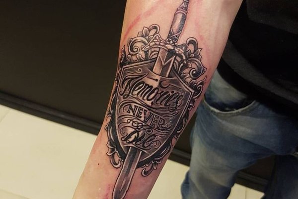 Татуировка щита на мужском предплечье