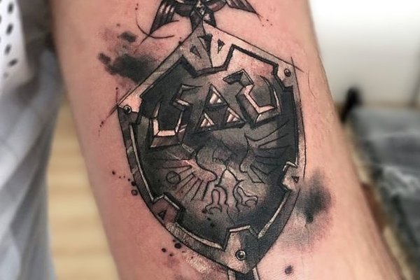 Татуировка щита на мужском плече